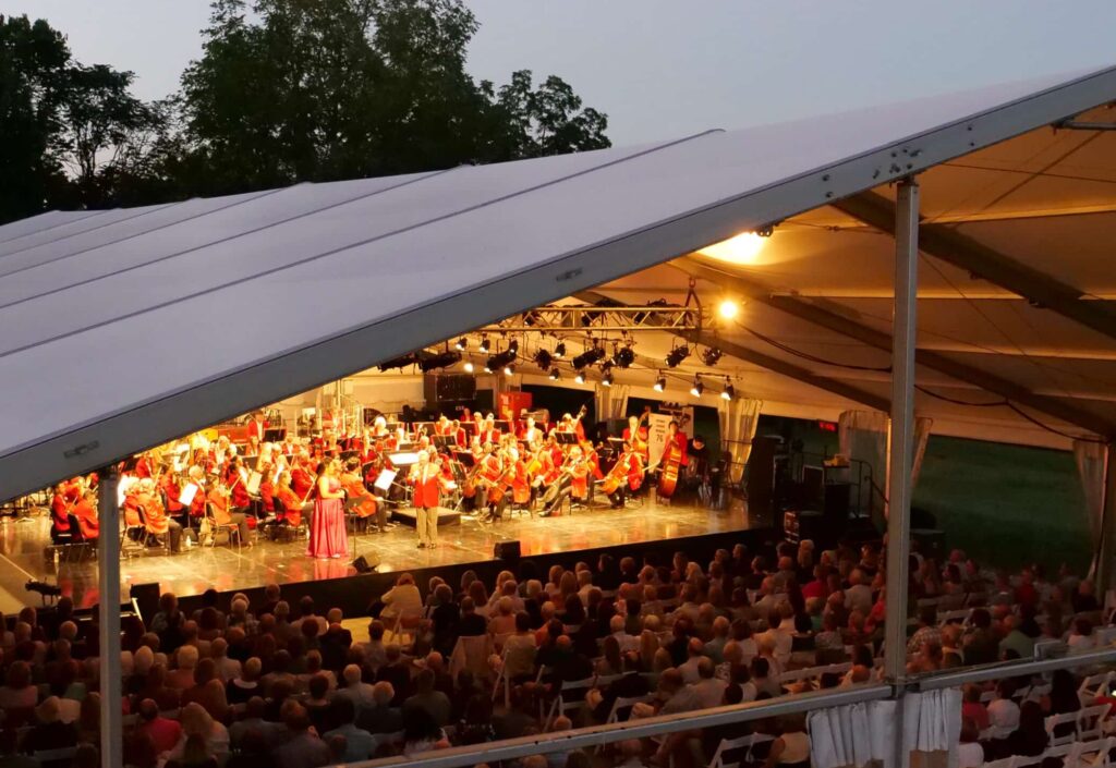 grand tent with music concert inside during twilight hour